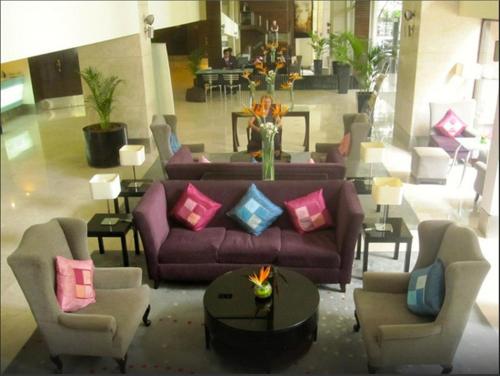 a living room with a purple couch and chairs at Royal Orchid Central Bangalore, MG Road in Bengaluru