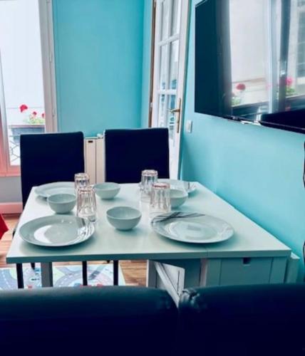 une table avec des bols et des assiettes en dessus dans l'établissement Apparemment - Tour Eiffel - Grenelle, à Paris