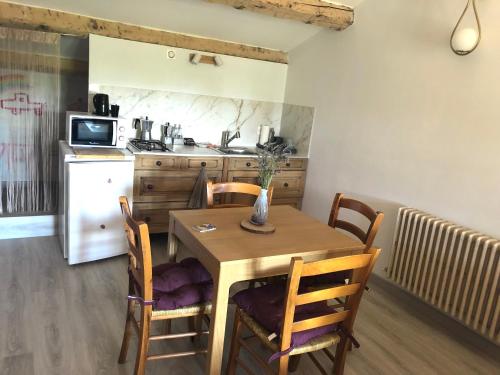 - une cuisine avec une table et des chaises en bois dans l'établissement La Respelido studio ds maison campagne, à Cabannes