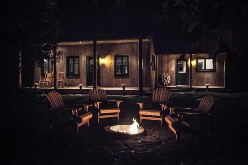 a fire pit in front of a house at night at Au Chic Chalet des Chutes Chic Chalet in Sainte-Melanie
