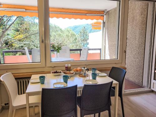 a dining room with a table and chairs and a window at Apartment Lago di Lugano Relax Apt-604 by Interhome in Bissone