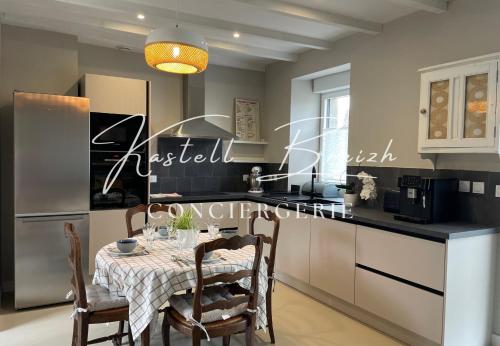 une cuisine avec une table et un réfrigérateur dans l'établissement Le gite Saint Guy, à Gommenec'h