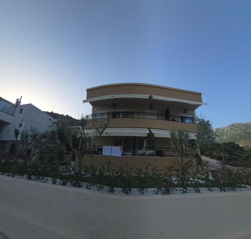 a building with a round top with trees in front of it at Deluxe Apartmani Vila Pejovic Sutomore in Sutomore