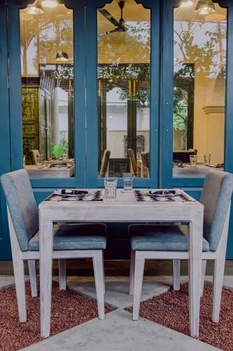 a wooden table with two chairs and a table and a table and chairs at Still Waters Artistry in Negombo
