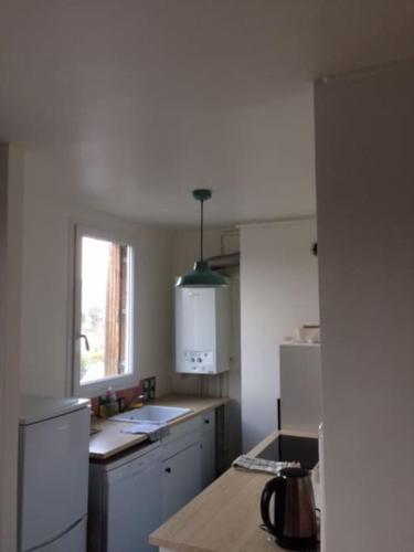 une cuisine avec un réfrigérateur et un plan de travail dans l'établissement Beau 3 pièces refait à neuf à Montreuil, à Montreuil