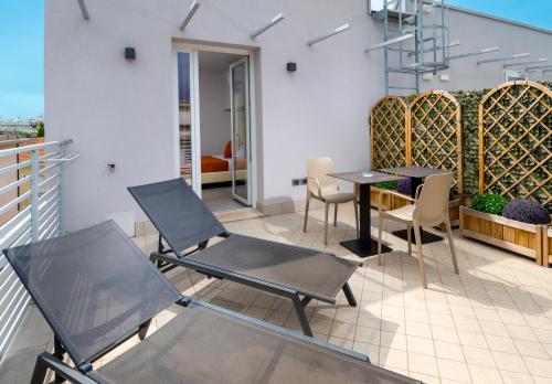 a patio with chairs and a table on a balcony at B&B Primrose Residence Hotel in Rimini