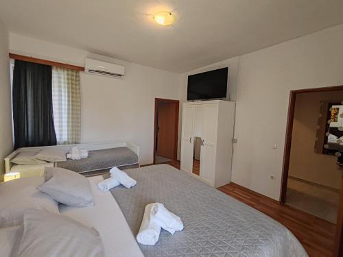 a hotel room with two beds and a flat screen tv at Apartments and pansion M&R in Turanj