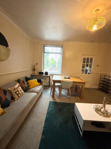 a living room with a couch and a table at HILLTOP PLACE SUITES 4 Bedrooms 6 BEDS for CONTRACTORS near M1J31 FREE PARKING FOR VANS in Killamarsh