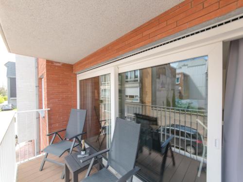 a balcony with two chairs and a sliding glass door at Apartment Medano-1 by Interhome in Bredene