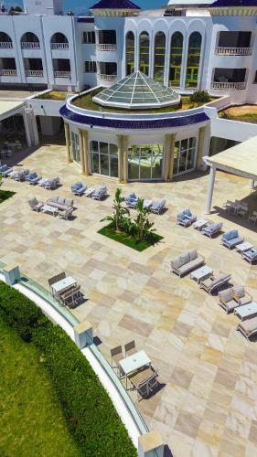 an aerial view of a resort with lounge chairs and a building at Royal Tulip Taj Sultan in Hammamet