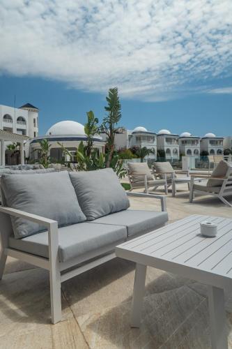 a couch and a table on a patio at Royal Tulip Taj Sultan in Hammamet