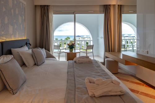 a bedroom with a large bed with towels on it at Royal Tulip Taj Sultan in Hammamet