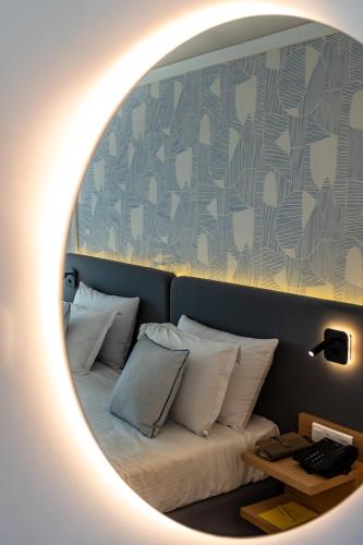 a room with a bed with a round mirror at Royal Tulip Taj Sultan in Hammamet