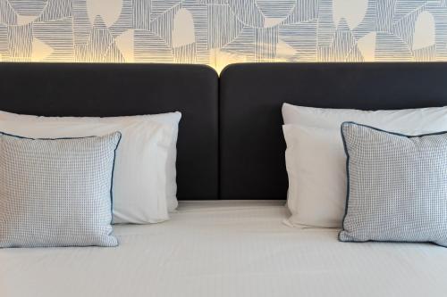 two pillows are sitting on a bed with two pillows at Royal Tulip Taj Sultan in Hammamet
