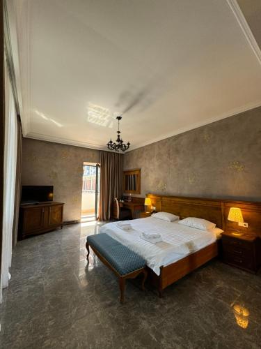 a bedroom with a large bed and a television at Boutique Hotel O. Galogre in Batumi