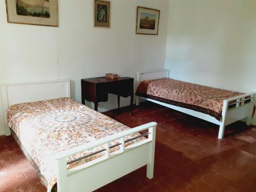 - 2 lits dans une chambre avec une table et une table dans l'établissement Location maison de campagne 5 personnes, à Quarante