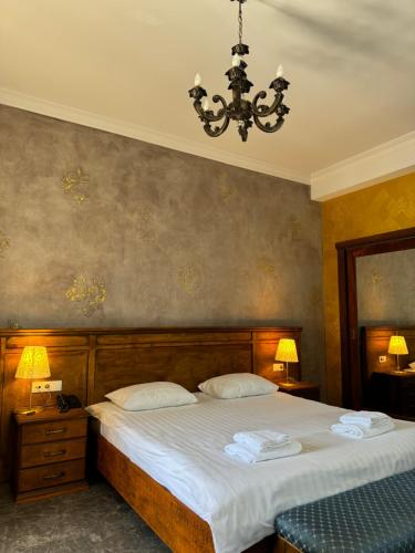 a bedroom with a large bed and a chandelier at Boutique Hotel O. Galogre in Batumi
