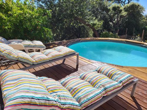 une terrasse avec deux chaises longues et une piscine dans l'établissement appartement avec terrasse et parking privé, à Vidauban
