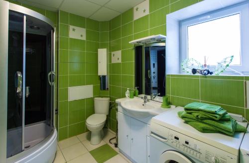 a green bathroom with a sink and a washing machine at Raigardo in Druskininkai