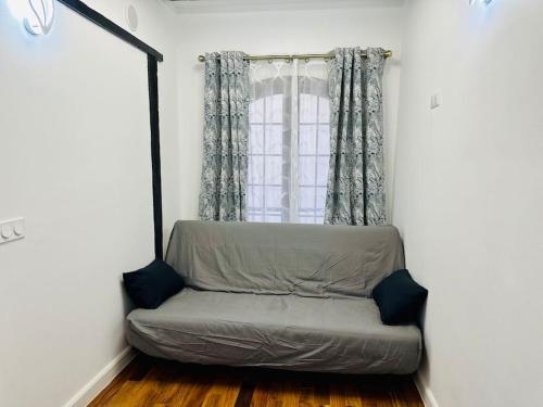 a couch sitting in a room with a window at Apparemment Tour Eiffel- La Motte Picquet Grenelle in Paris