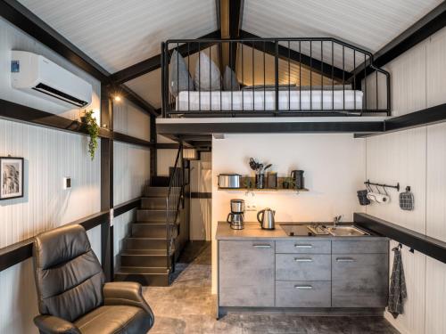 a tiny house with a loft bed and a kitchen at Holiday Home Tiny Haus Westerwald 16 Red by Interhome in Bad Marienberg