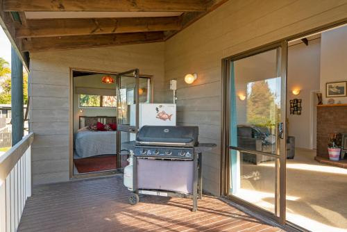 a barbecue grill on a porch of a house at 5 o'clock Somewhere - Tairua Holiday Home in Tairua