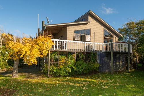 a house with a deck on the side of it at 5 o'clock Somewhere - Tairua Holiday Home in Tairua