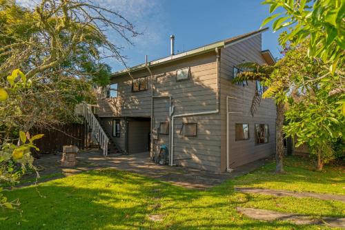 a house with a garage and a yard at 5 o'clock Somewhere - Tairua Holiday Home in Tairua