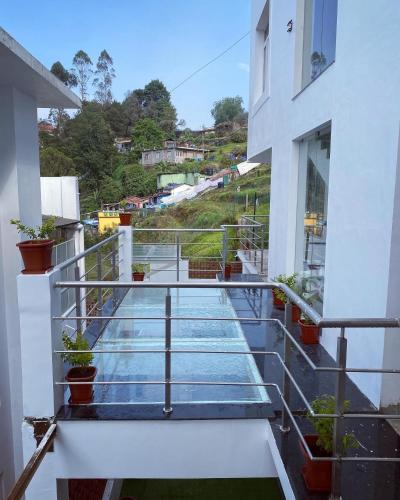 a balcony of a building with stairs and plants at SRI VARİ studio Apartments in Kodaikānāl