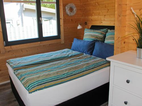 a bed with a striped blanket on it in a room at Holiday Home Ferienhaus Sarahlita by Interhome in Enspel