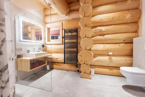 baño con pared de madera, aseo y lavamanos en Chalet Tannenhaus, en Gmünd in Kärnten