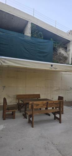 three wooden benches sitting in front of a building at Deluxe Apartmani Vila Pejovic Sutomore in Sutomore