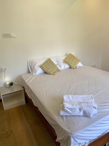a white bed with two towels on top of it at SRI VARİ studio Apartments in Kodaikānāl