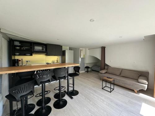 - une cuisine et un salon avec un comptoir et des tabourets dans l'établissement Viens dans mon beau jardin ! 012, à Rouen