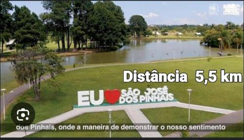 a sign in front of a park with a lake at Apartamento in São José dos Pinhais