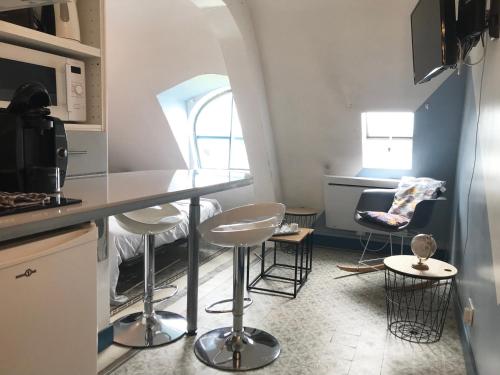 une cuisine avec un comptoir et des tabourets dans une pièce dans l'établissement L'ASTORIA 6 - Centre Ville - Proche des Thermes - Ancien Palace, à Vichy