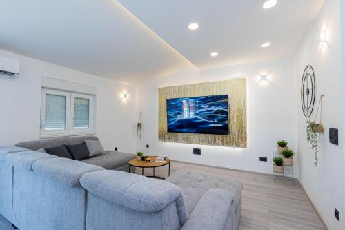 a living room with a blue couch and a table at Luxury Apartment SeaYou Kaštela in Kaštela