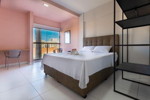 ナタールにあるCity Studios Housi Natal by Carpediemの大きなベッドと大きな窓のある寝室