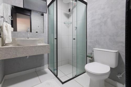 ナタールにあるCity Studios Housi Natal by Carpediemのトイレとガラスのシャワー付きのバスルーム
