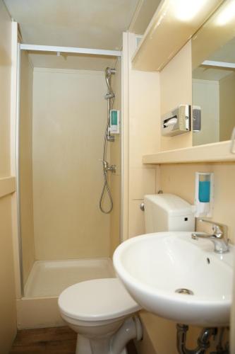 a bathroom with a sink and a toilet and a shower at Hotel CityRing in Frankfurt/Main