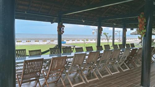a long table with chairs on the beach at Biển Ngọc Homstay in Ấp Sung Xuân