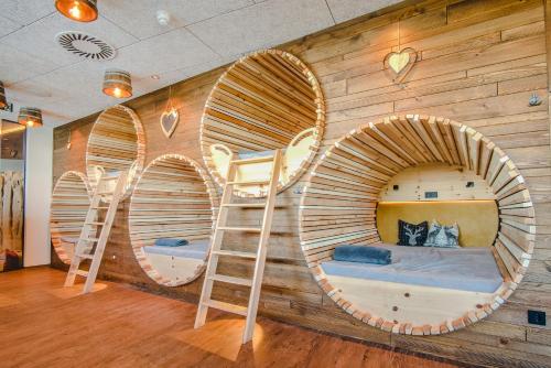 a room with three bunk beds in a wooden wall at Bier und Wohlfühlhotel Gut Riedelsbach in Neureichenau
