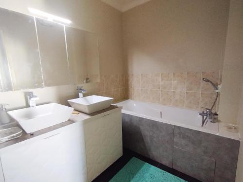 La salle de bains est pourvue d'une baignoire, d'un lavabo et d'une baignoire. dans l'établissement Appartement avec vue près des plages, à Sète