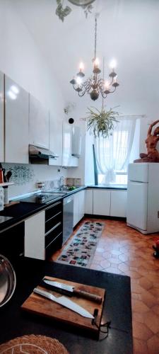 a kitchen with a counter and a chandelier at Appartamento Arte in Imperia
