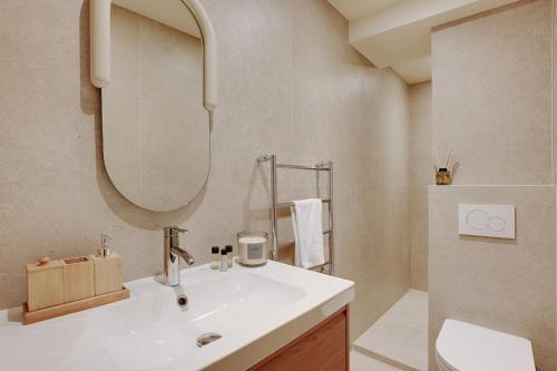 une salle de bain avec un lavabo et un miroir dans l'établissement Suite BellesFeuilles - Terrasse, à Paris