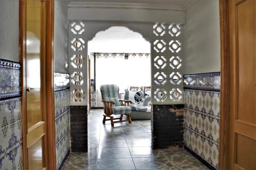 a living room with a chair and a window at Vacansis Habitaciones Privada en una Villa a un paso del Mar en Cullera in Cullera