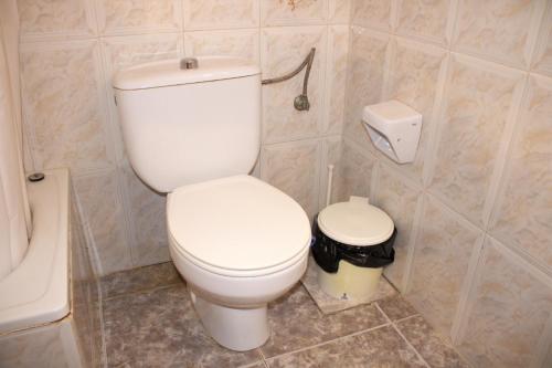 a bathroom with a white toilet and a trash can at Vacansis Habitaciones Privada en una Villa a un paso del Mar en Cullera in Cullera