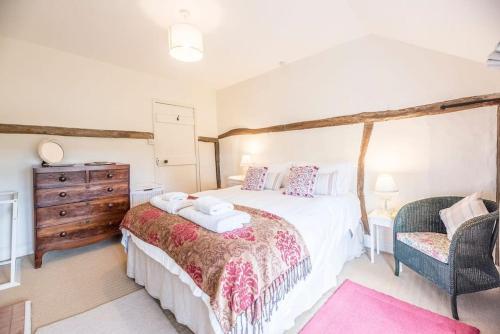 una camera da letto con un letto grande e una sedia di Angel Cottage, Wenhaston a Halesworth