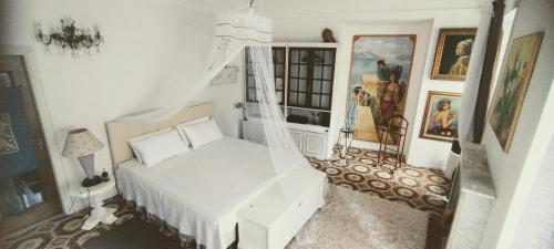a bedroom with a white bed and paintings on the wall at Appartamento Arte in Imperia