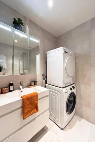 a bathroom with a washing machine and a sink at Arctic City Studio - perfectly located in the main street in Tromsø